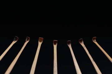 Handmade bamboo ear wax remover on black background.