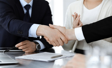 Business people shaking hands after contract signing in modern office. Teamwork, partnership and handshake concept