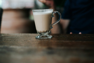 an elderly man sits on the street and drinks coffee