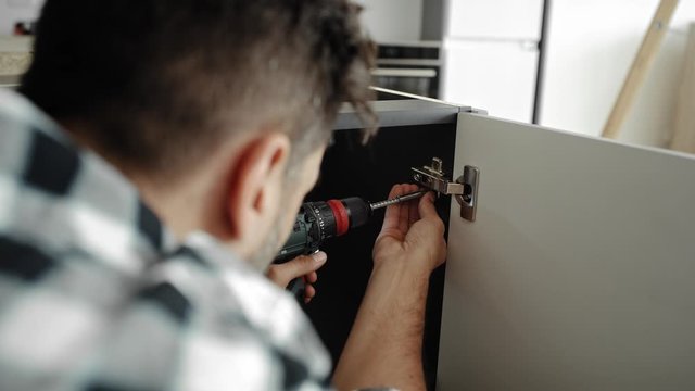 Rear view video of screwing hinges with a cordless screwdriver. Shot with RED helium camera in 8K