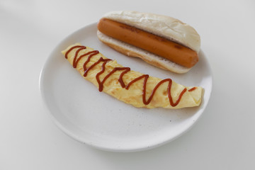 Simple easy breakfast of omelette and sausage served on white dish.