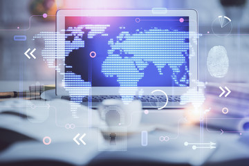 Double exposure of desktop with computer and world map hologram. International data network concept.