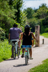 Naklejka premium couple cycling along dirt track 