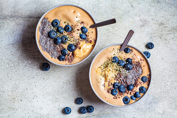 Vegan breakfast - chocolate smoothie bowl with chia pudding, peanut butter and berries in gray bowl.