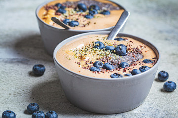 Vegan breakfast - chocolate smoothie bowl with chia pudding, peanut butter and berries in gray bowl.