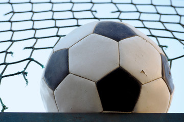 soccer ball in black and white on the background of the grid and the sky