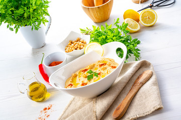 hummus paste with lemon and chilli on white background