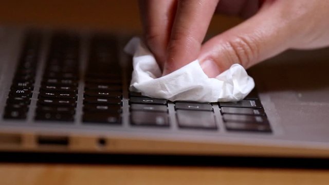 Hand wiping table desk surface using disinfectant to prevent COVID-19 pandemic virus from spreading