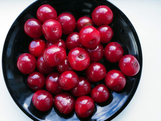 ripe cherries on a black plate