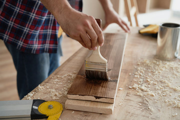  Man painting boards with a brush