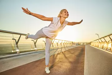 Fotobehang Gymnastiek Cheerful woman doing morning gymnastics on the street  © Viacheslav Yakobchuk