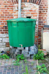 Obraz premium Zisterne, Regenwasser, Grauwasser sammeln zur Bewässerung, Auffangen vom Regenwasser des Dach und damit Wasser sparen, altes Wasserfass, Plastefass