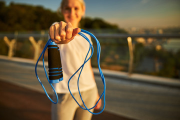 Sporty woman holding skipping rope for training