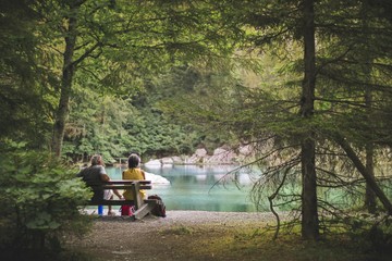 a couple sitting in front of the Lac Vert, in the city of Passy, France