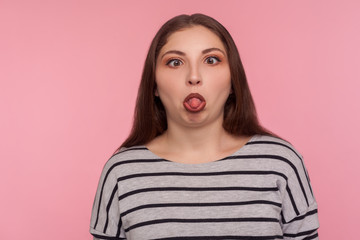 Portrait of funny dumb amusing woman in striped sweatshirt standing with crossed eyes, showing...