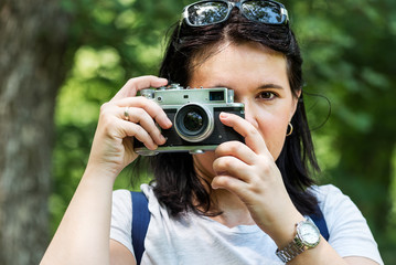 Woman taking photo at park outdoor with copy space. Beautiful woman tourist photographer with vintage camera. lady photographer, female Portrait.