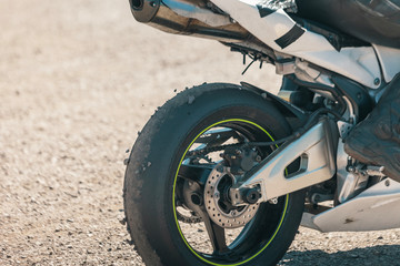 Close up of Race Rear Tire with disk brake on a Sport Bike After Track with stones from track