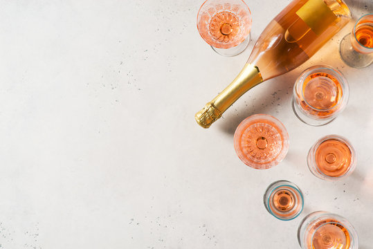 Bottle of rose sparkling wine or champagne on white or light grey background
