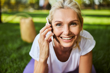 Beautiful joyful woman having phone conversation on the street