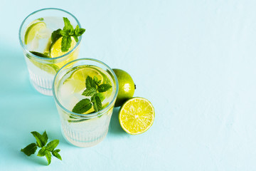 Summer coctail or mocktail mojito with lime and mint leaf on blue background