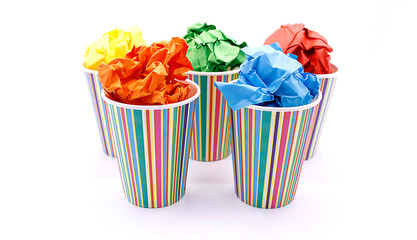 Colored wrinkled paper and paper cup, close up on white background