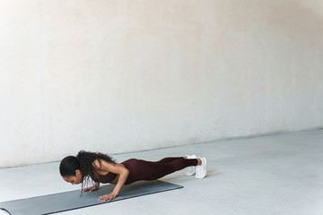 Photo of african american woman doing exercise on mat while working out