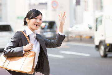タクシーを停めるOL