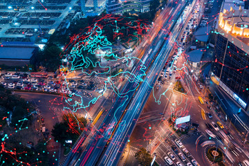 Fototapeta na wymiar World planet Earth map hologram on aerial view of road, busy urban traffic highway at night. Junction network of transportation infrastructure. The concept of success in logistics business.
