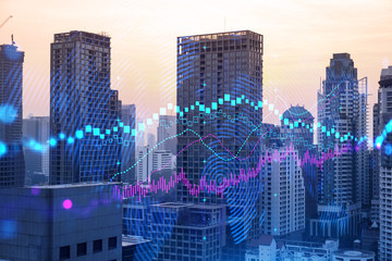 Obraz premium Glowing FOREX graph hologram, aerial panoramic cityscape of Bangkok at sunset. Stock and bond trading in Asia. The concept of fund management. Double exposure.