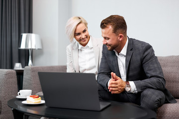 Obraz premium business coworkers discuss ideas, sit with laptop isolated in room, blonde lady and bearded guy in formal wear have successful cooperation