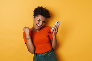 Image of african american woman making winner gesture and cellphone - Powered by Adobe