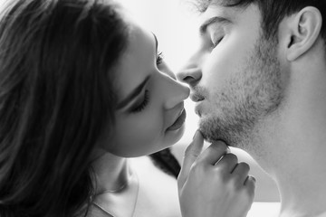black and white shot of sexy couple kissing at home