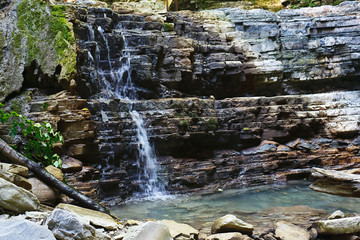 Refreshing stream of mountain brook falling from the rocks.