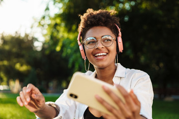 Fototapeta premium Woman outdoors in park listening music
