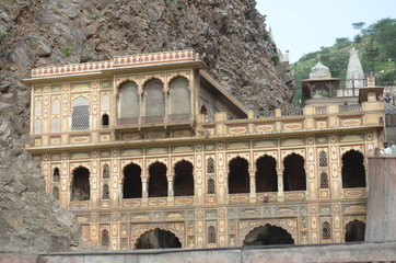 Obraz premium Galtaji is an ancient Hindu pilgrimage about 10 km away from Jaipur, in the Indian state of Rajasthan. The site consists of a series of temples built into a narrow crevice in the ring of hills that su