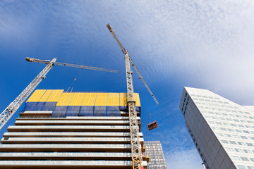 Construction site with two cranes hoisting construction material in Rotterdam in the Netherlands