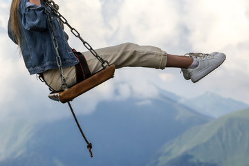 The girl took off on a swing into the clouds.