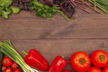 Background of fresh vegetables and greens on a wooden table. View from above.