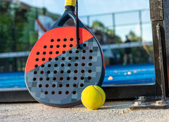Paddle-Tennis: Padle Schläger und Ball vor einem Outdoor Court
