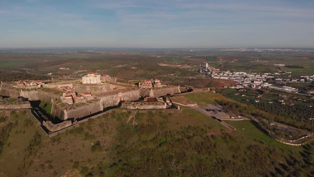 Dolly zoom on the white governor's house in the center of Fort of Nossa Senhora da Graca is set against the horizon of blue sky.