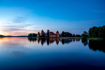 Fototapeta premium Trakai Castle after sunset in the lake Galve, Lithuania