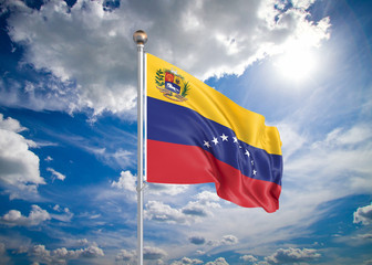 Realistic flag. 3D illustration. Colored waving flag of Venezuela on sunny blue sky background.