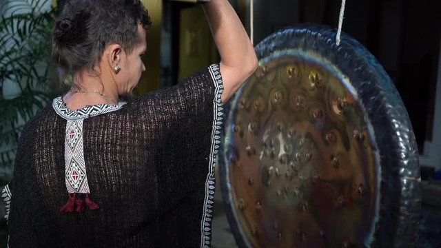 Handsome man playing in ancient mystical gong musical instrument
