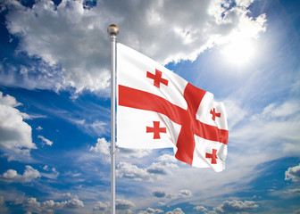 Realistic flag. 3D illustration. Colored waving flag of Georgia on sunny blue sky background.
