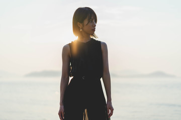 Fototapeta premium 夕陽の海にいる女性