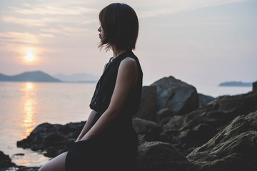 夕陽の海にいる女性