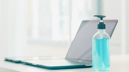 Hand sanitizer gel for hand hygiene corona virus protection with computer laptop. Social distancing stay at home and self quarantine time, online shopping, coronavirus concept.