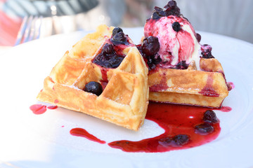 Belgian waffles with ice cream and jam on a restaurant