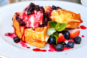Belgian waffles with ice cream and jam on a restaurant