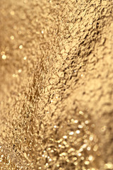 Gold crumpled glittering background.
